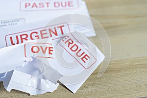 Debt letters that are collected on past overdue bills and final announcements on the table. Red writing to represent the struggle