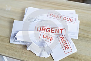 Debt letters that are collected on past overdue bills and final announcements on the table. Red writing to represent the struggle