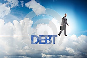 The debt and loan concept with businessman walking on tight rope