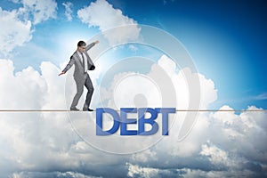 The debt and loan concept with businessman walking on tight rope