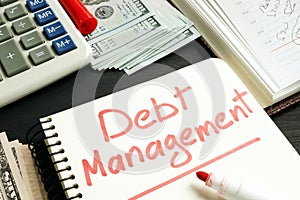 Debt management. Notepad, calculator and money.