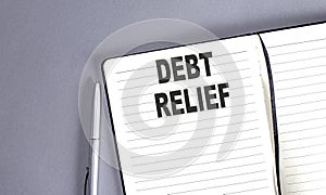 DEBT RELIEF word on the notebook with pen