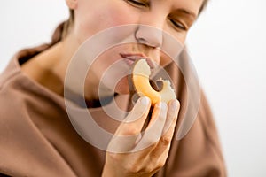 Decadent delight: An attractive woman in her prime relishing the sinful pleasure of a chocolate-covered donut