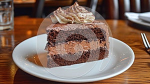 A decadent slice of chocolate cake with rich frosting on a white plate