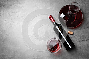 Decanter, glass and bottle with red wine on color background, flat lay.