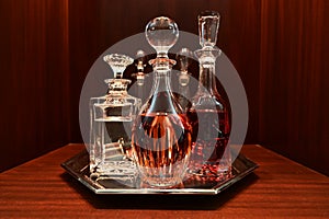 Decanters on silver tray containing variety of liquors.