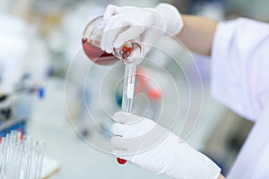 Decanting a violet liquid into a graduated cylinder