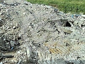 Decayed concrete from a collapsed building Lots of cement debris piled up on the floor.