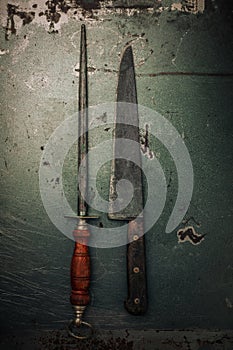 Decayed metallic texture with set of old knife sharpener and knife