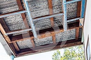 A decayed wood structure under the zinc roof of a house