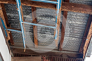 A decayed wood structure under the zinc roof of a house