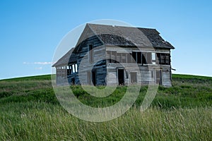 Decaying, abandoned spooky old farmhouse shack in the rolling hills of the Palouse region of Washington State