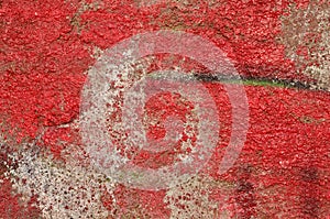 Decaying red graffiti on concrete wall.