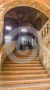 Decaying staircase and hall of a former palazzo in Piacenza, Italy