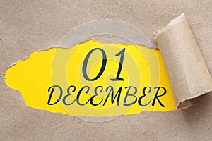 december 01. 01th day of the month, calendar date.Hole in paper with edges torn off. Yellow background is visible