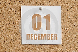 december 01. 01th day of the month, calendar date.White calendar sheet attached to brown cork board.Winter month, day of