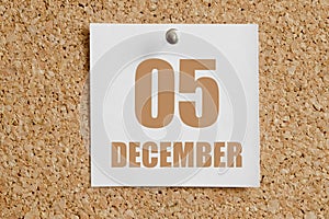 december 05. 05th day of the month, calendar date.White calendar sheet attached to brown cork board.Winter month, day of