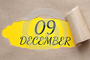 december 09. 09th day of the month, calendar date.Hole in paper with edges torn off. Yellow background is visible