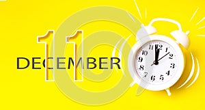 December 11st . Day 11 of month, Calendar date. White alarm clock with calendar day on yellow background. Minimalistic concept of