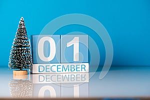 December 1st. Day 1 of december month, calendar with little christmas tree on blue background. Winter time. Empty space