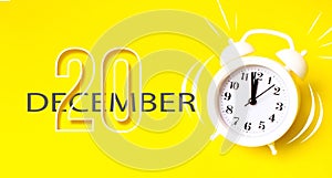 December 20th. Day 20 of month, Calendar date. White alarm clock with calendar day on yellow background. Minimalistic concept of