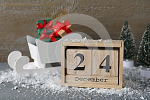 December 24 - Christmas Eve. Wooden block calendar and decor on grey table