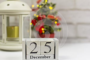 December 25 on a white wooden calendar on a light background next to the Christmas tree.The Concept Of Christmas