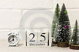 December 25th on a calendar on a wooden background next to the Christmas tree.Christmas concept