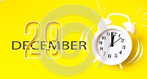 December 29th. Day 29 of month, Calendar date. White alarm clock with calendar day on yellow background. Minimalistic concept of