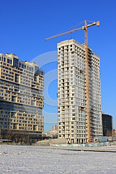 December 5, 2020 Moscow, Russia. Crane and building construction site against blue sky