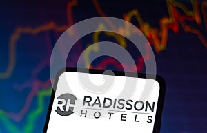 December 8, 2021, Brazil. In this photo illustration the Radisson Hotels logo seen displayed on a smartphone and in the background