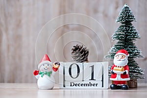 1 December calendar with Christmas decoration, snowman, Santa claus and pine tree  on wooden table background, preparation for