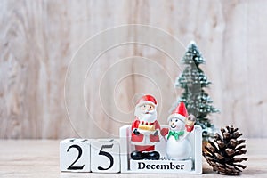 25 December calendar with Christmas decoration, snowman, Santa claus and pine tree  on wooden table background, preparation for