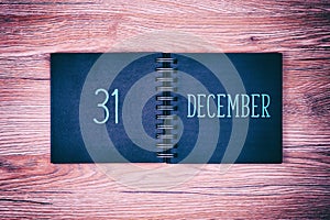 31. December. Desk calendar on wooden background. New year background.