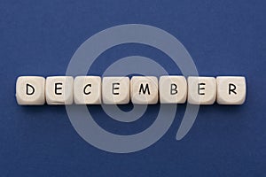 December lettering. Wooden blocks with december word over clasic blue blackground. Copy space photo