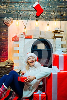 December surprise and party time. Young woman with christmas present boxes in front of christmas tree. Expressions face