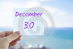 December 30th. Hand holding sticker with text December 30. Month in calendar concept