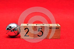 25 December on wooden blocks with a silver bell