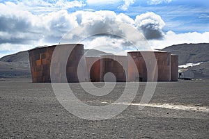 Deception Island, Antarctica. Tanks of abandoned whale station with cruise liner in background. Lost places,