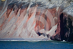 Deception Island, South Shetland Islands, Antarctica, part of orange steep rugged rocks of Whalers