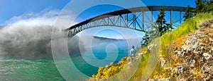 Deception pass bridge and woman looking at scenic views.