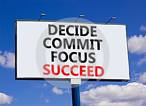 Decide commit focus succeed symbol. Concept word Decide Commit Focus Succeed on beautiful big billboard. Beautiful blue sky cloud