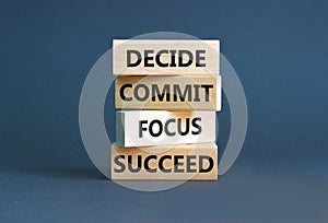 Decide commit focus succeed symbol. Concept word Decide Commit Focus Succeed on wooden block. Beautiful grey background. Business