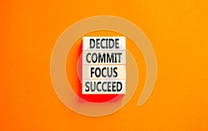 Decide commit focus succeed symbol. Concept word Decide Commit Focus Succeed on wooden block. Beautiful orange table orange
