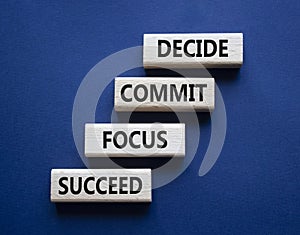 Decide Commit Focus Succeed symbol. Concept words Decide Commit Focus Succeed on wooden blocks. Beautiful deep blue background.