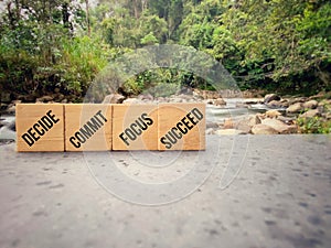 DECIDE COMMIT FOCUS SUCCEED text on wooden blocks in vintage background. Inspirational and motivational concept. Stock photo.