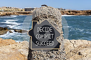 Decide commit succeed symbol. Concept word Decide Commit Succeed on beautiful black chalk blackboard. Beautiful stone beach sea