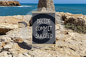 Decide commit succeed symbol. Concept word Decide Commit Succeed on beautiful black chalk blackboard. Beautiful stone beach sea