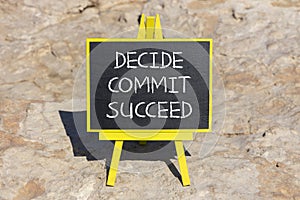 Decide commit succeed symbol. Concept word Decide Commit Succeed on beautiful black chalk blackboard. Red stone. Beautiful red
