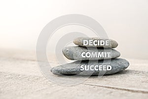 Decide, commit and succeed words written on stones. Motivational advice or reminder